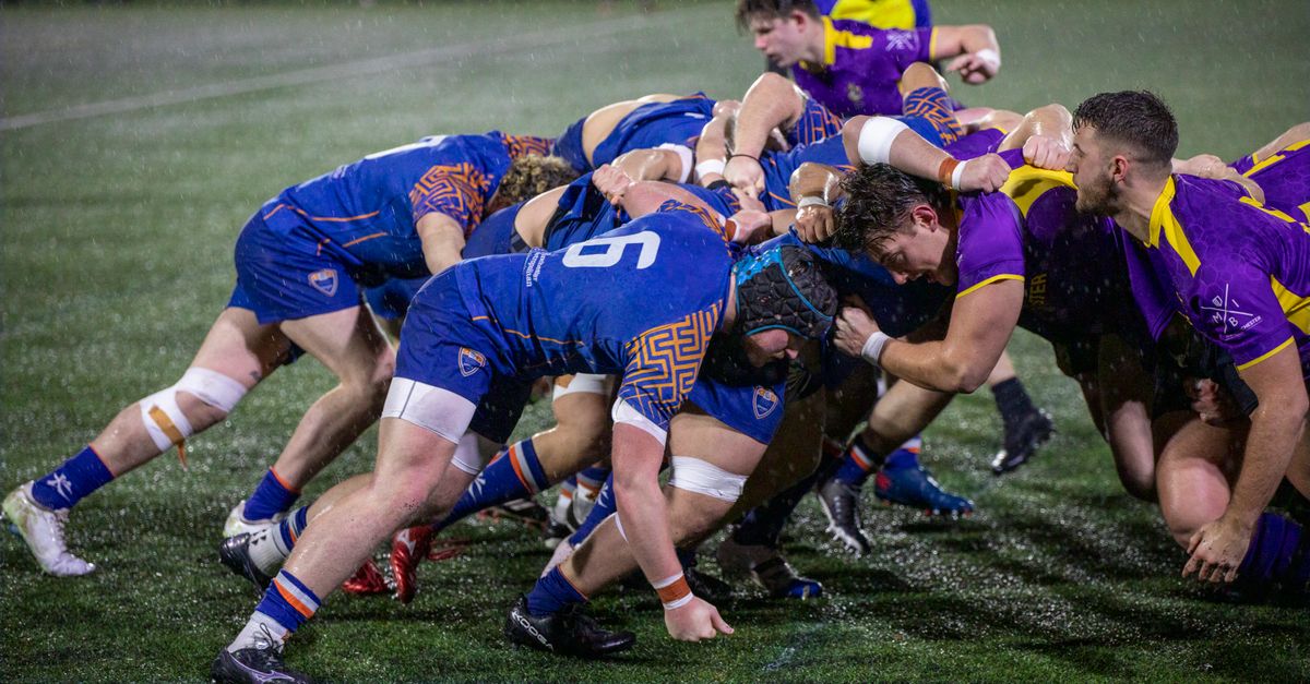 A dynamic rugby scrummage during a match in Manchester, England.